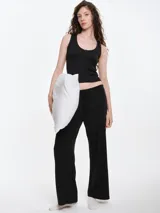 Pantalón de dormir de corte recto y holgado, confeccionado en tejido suave con textura acanalada. Presenta cintura elástica con cordón ajustable y bolsillos laterales.