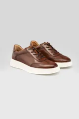 Championes de cuero marrón con cordones a tono y suela blanca texturizada.