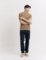 Pantalón de vestir marrón, de corte recto, con bolsillos laterales y traseros. Se ajusta a la cintura con cinturón de cuero marrón.