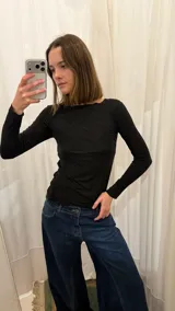 Remera de manga larga con cuello redondo, confeccionada en tejido de punto suave y elástico, con un ajuste al cuerpo.