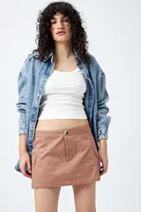 Minifalda color beige estilo cargo, de tiro bajo y corte recto, con bolsillos laterales.