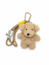 Llavero con diseño de osito de peluche beige rizado, con un lazo en el cuello, correa de cordón beige, detalle de hilo amarillo y mosquetón metálico.