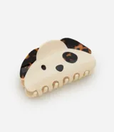 Pinza para el cabello con diseño de cara de perro, en tonos crema y carey, fabricada en acetato con mecanismo de cierre metálico.