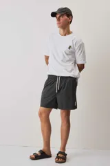 Short de baño color gris oscuro, con cintura elástica ajustable mediante cordones blancos y un pequeño parche decorativo en el borde inferior.