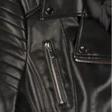 Campera de cuero sintético negro estilo biker, con cierre frontal cruzado, solapas con broches y herrajes plateados. Presenta bolsillos con cierre en el frente y detalles pespuntados en los hombros y los puños.