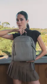 Mochila de diseño estructurado en color bordó, confeccionada en símil cuero con costuras decorativas en forma de rombos en el frente. Cuenta con un bolsillo frontal con cierre, asa superior de mano y correas regulables.