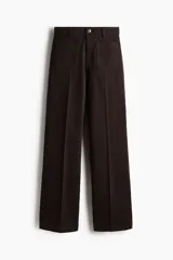 Pantalón jean de tiro alto en color marrón, de corte amplio y relajado, con bolsillos delanteros de parche y raya marcada al frente.