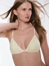Bralette de encaje color beige con diseño triangular, breteles ajustables y cierre posterior con broche. Cuenta con copas removibles y detalle de pequeño lazo en el centro.