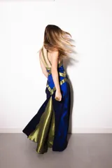 Vestido largo de tafeta azul con detalles de recortes geométricos en contraste de color verde militar, con diseño halter cruzado y silueta ajustada al cuerpo.