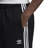 Pantalón Adidas Classics Superstar negro con tres rayas blancas a los costados y logo de la marca bordado en el muslo.