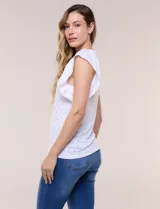 Blusa blanca de tejido calado estilo broderie con escote en V y mangas cortas tipo mariposa.