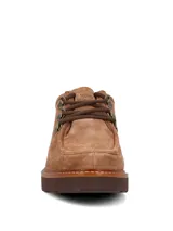 Zapato acordonado de estilo robusto, confeccionado en descarne color marrón. Presenta suela gruesa de goma con plataforma, costuras a la vista y detalles de herrajes metálicos en los ojales de los cordones.