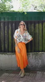 Falda midi evasé de raso color negro, con cintura elástica y cinturón con apliques metálicos.