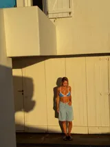 Bikini de dos piezas color azul con bordes en contraste blanco. El corpiño es de estilo triangular fijo y la bombacha es de corte clásico con tiras laterales ajustables.