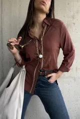 Camisa de tejido liviano y calce relajado, color marrón chocolate, con cuello mao, mangas largas y detalle de puntilla y bordado en contraste a lo largo de la botonadura frontal.