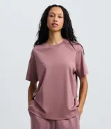 Remera de corte boxy con cuello redondo y mangas cortas. Confeccionada en algodón, presenta un diseño minimalista sin estampas con sisa caída.