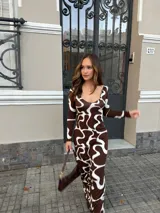 Vestido largo de viscosa con estampado abstracto en tonos marrón y blanco, de corte ajustado, escote redondo amplio y mangas largas.
