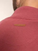 Campera color beige de tejido de punto con cierre frontal y cuello alto.