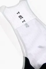 Short de ciclismo con tirantes, color blanco, de tejido elástico y diseño ergonómico con badana y detalles gráficos en negro.