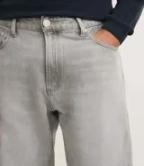 Pantalón de jean recto color gris claro, con cintura media, cierre de botón metálico y cremallera. Incluye bolsillos delanteros, un bolsillo monedero pequeño y bolsillos traseros aplicados.