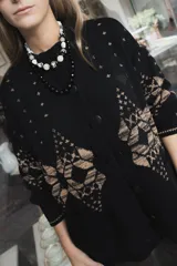 Saco de punto gris con diseño geométrico en color amarillo, cierre frontal con botones, cuello redondo y bordado de corazón pequeño en el pecho.