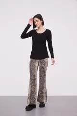 Remera blanca de manga larga, entallada, con cuello redondo y una hilera de botones en el frente. Incluye un pequeño bolsillo decorativo en el pecho.