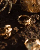 Anillo abierto de diseño orgánico con textura irregular y acabado brillante, realizado artesanalmente en metal.