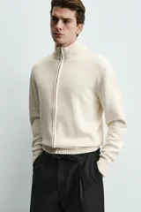 Chaqueta regular fit de punto color beige con cuello perkins, manga larga y cierre frontal con cremallera.