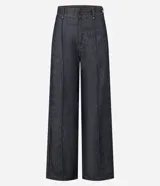Pantalón wide leg de tiro alto confeccionado en denim de algodón. Presenta una pretina tipo sastrería con presillas, cierre frontal con botón y cremallera, bolsillos funcionales y nervaduras frontales que definen la silueta.