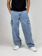 Pantalón de jean celeste con lavado ácido, corte ancho (baggy) y múltiples bolsillos cargo.