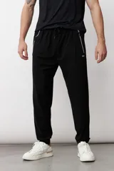 Pantalón deportivo de corte recto y ajuste holgado, color negro, con cintura elástica con cordón ajustable, bolsillos laterales con cierre y detalle de logo pequeño en el muslo.