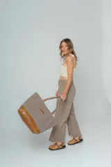 Bolso tipo tote de lona color crudo con base y asas de cuero color marrón.