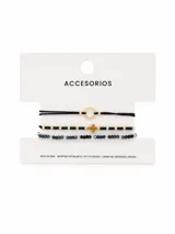 Set de tres pulseras con diseños variados: una pulsera de hilo negro con un aro metálico dorado, una pulsera de cuentas negras y doradas con un dije de cruz central, y una pulsera de cuentas facetadas oscuras.