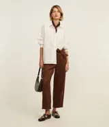 Pantalón de gamuza color marrón chocolate, de corte recto y tiro alto, con cinturón de tela a tono.