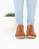 Zapato bajo de cuero negro con puntera redondeada y cierre frontal con cremallera doble.