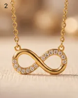 Collar de acero con baño de oro, con dije en forma de símbolo de infinito parcialmente incrustado con circonias.
