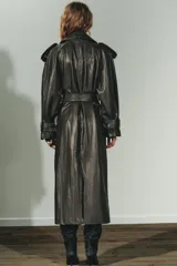 Trench coat de Zara con efecto piel texturizada en color gris oscuro. Presenta cuello con solapas, cierre frontal cruzado con botones, cinturón lazada del mismo material, mangas largas con trabillas y abertura en la espalda.