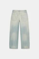 Jeans de tiro medio y corte ancho, confeccionados en denim con lavado estilo vintage de efecto desgastado. Presentan diseño de doble cinturilla superpuesta, cinco bolsillos tradicionales, trabillas para cinto y cierre frontal con cremallera y botón metálico.