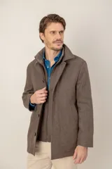 Chaquetón de lana con diseño de espiga, cuello alto tipo rib y cierre frontal con cremallera y botones.