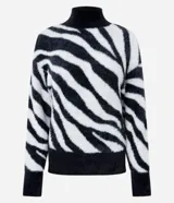 Suéter de cuello alto con textura peluciada y estampado de cebra en blanco y negro. Presenta puños y ruedo acanalados en color negro sólido.