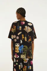 Remera negra de manga corta y cuello redondo, con estampado ilustrado de temática tropical y urbana.