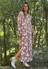 Vestido largo color lila con estampado abstracto en blanco, cuello en V con lurex y mangas largas.