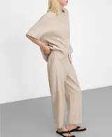 Pantalón de pierna recta y largo tobillero, color beige con diseño microdibujo. Cuenta con cinturilla elástica en los costados, bolsillos laterales y un bolsillo de vivo con botón en la espalda.