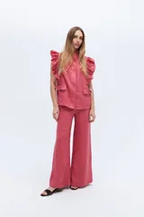 Pantalón palazzo color coral de lino con cintura alta y bolsillos laterales.