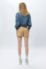Short color beige de tiro alto y tela liviana con grandes bolsillos.