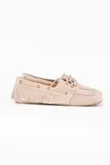 Mocasín de gamuza color beige, con flecos en los laterales y cordones decorativos.
