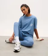 Remera oversized deportiva de algodón color azul, con cuello redondo, manga corta y estampado de lettering en el pecho.