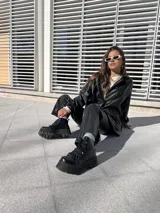 Botas negras de ecocuero con detalle de cadena en la parte delantera y taco de 6cm.