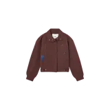 Campera Eme Studios de corte corto y estilo utilitario, color marrón oscuro con textura sutil, bolsillos frontales amplios, cuello clásico y detalles de broches metálicos dorados.