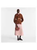 Cartera tipo tote en tamaño XS, confeccionada en cuero color marrón, con diseño estructurado, asas cortas y cierre de solapa con botón a presión metálico.